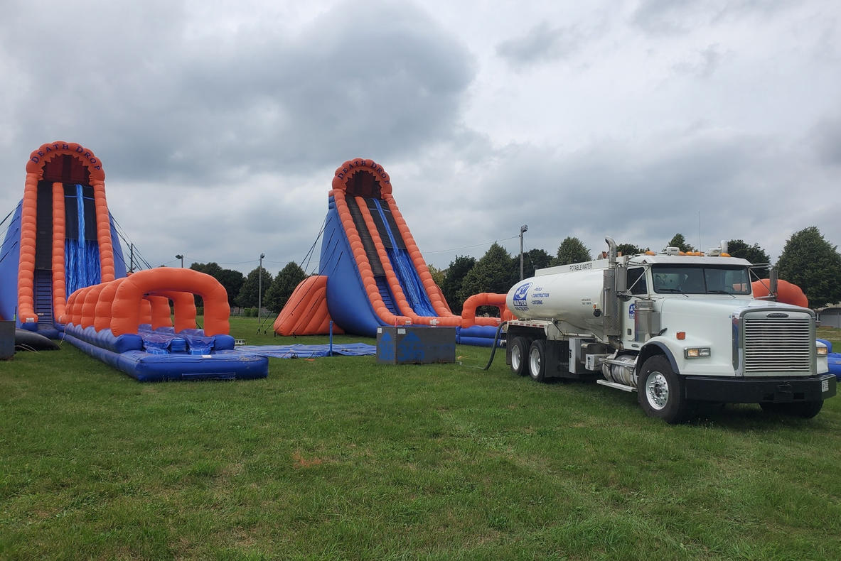 J and M Water Truck Inc. (Brantford) volunteer at a community event, delivering water for blow up water slide slides.